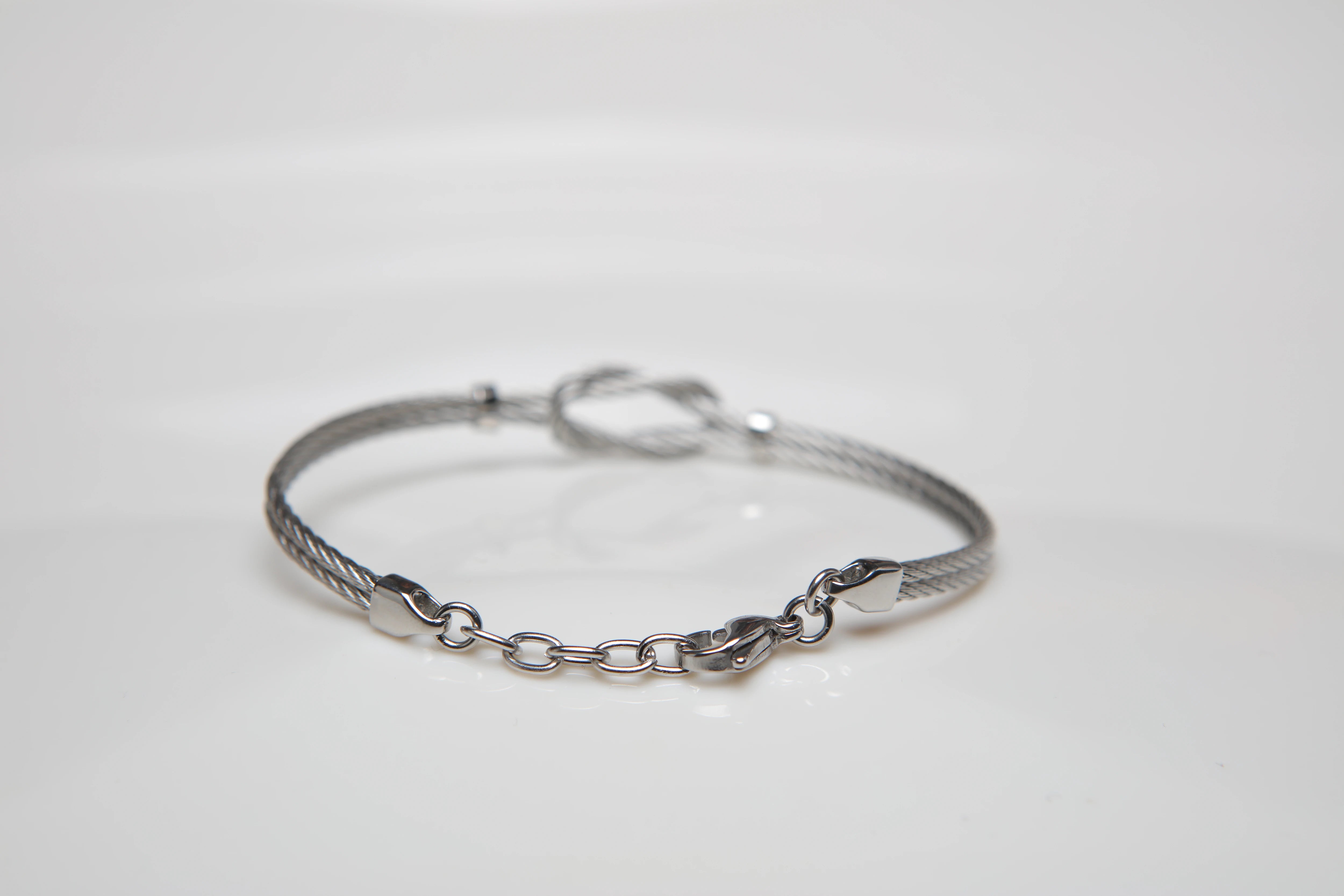 Stainless steel cable bracelet with knot and screws in 18kt gold